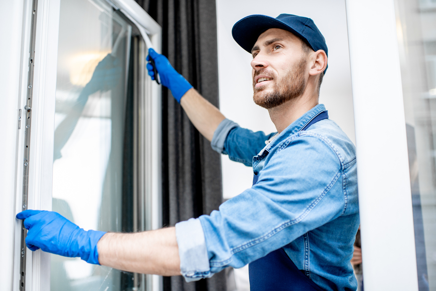 Housekeeper Cleaning Glass Window